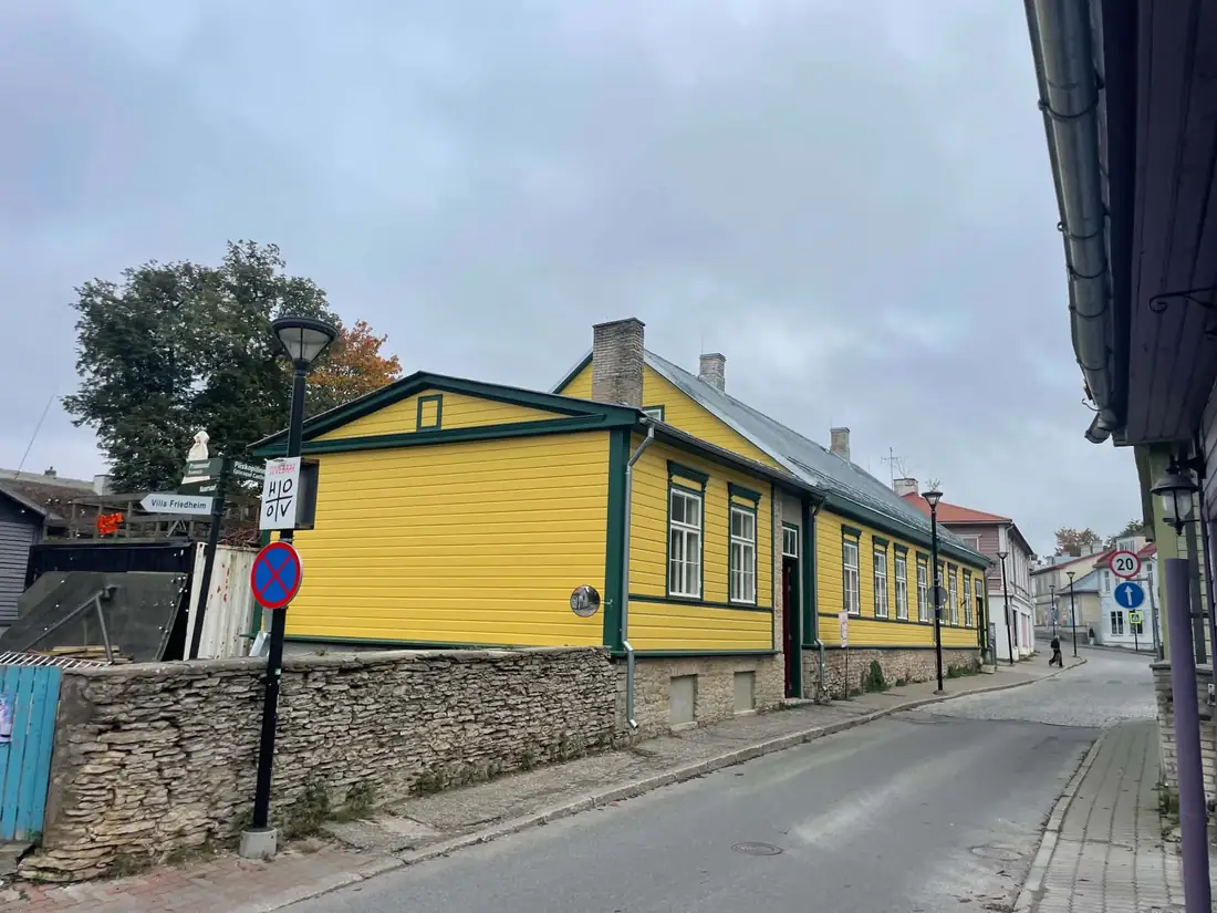 Valminud puitmaja kollase voodri ja roheliste piirdelaudadega